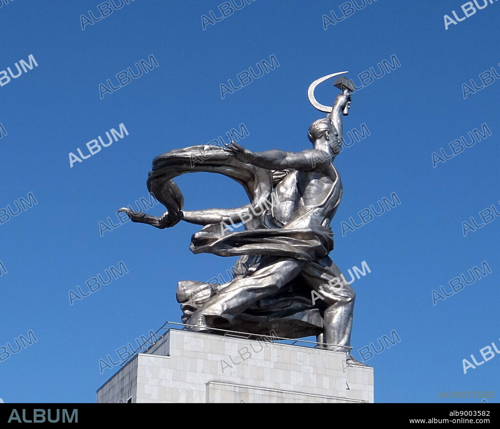 Worker and Kolkhoz Woman sculpture in Moscow, depicts of two figures with a sickle and a hammer raised over their heads. It is 24.5 meters (78 feet) high, made from stainless steel by Vera Mukhina for the 1937 World's Fair in Paris and subsequently moved to Moscow. The sculpture is an example of the socialist realistic style, as well as Art Deco style. The worker holds aloft a hammer and the kolkhoz woman a sickle to form the hammer and sickle symbol.