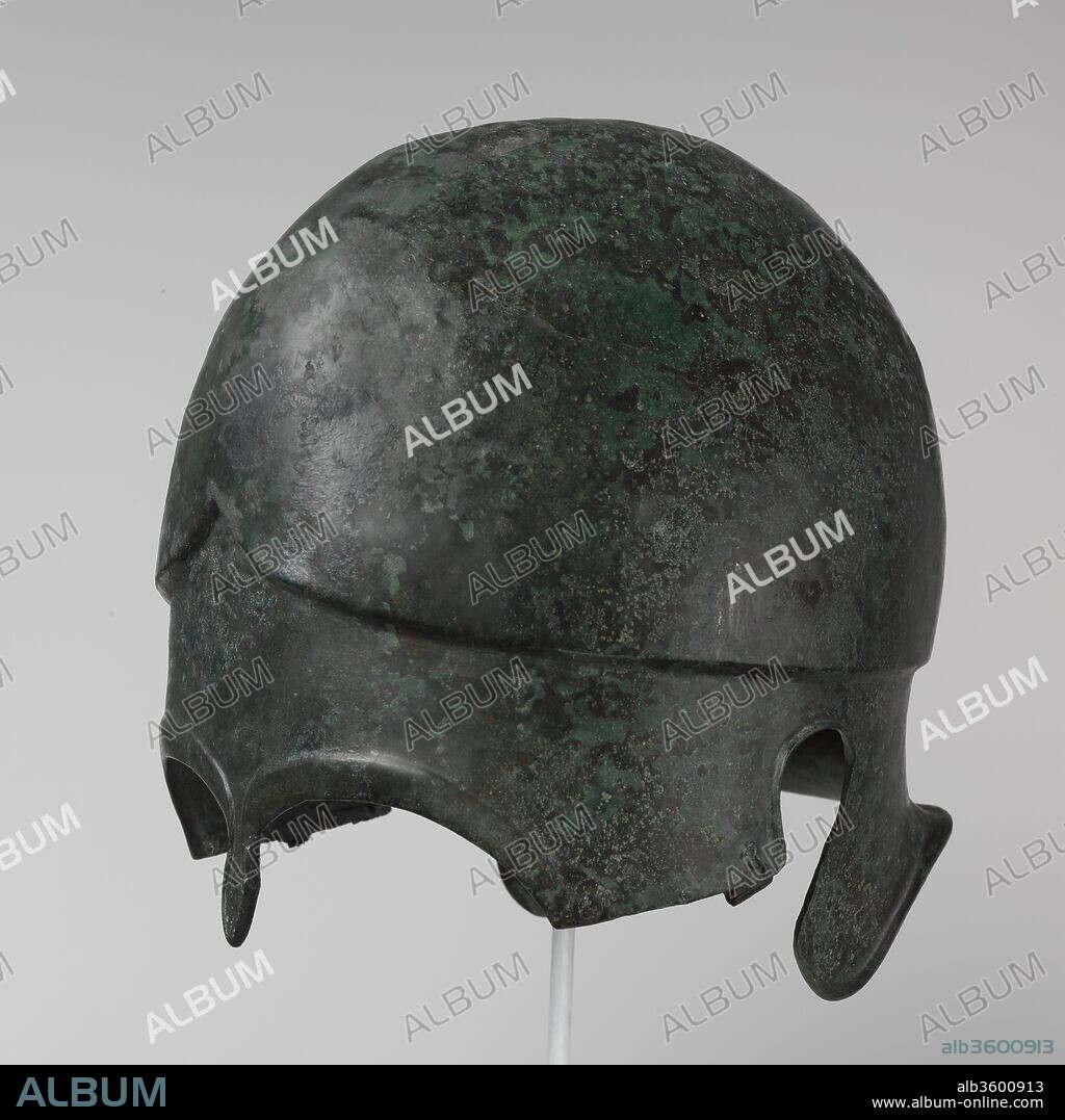 Bronze helmet of Chalcidian type. Culture: Greek. Dimensions: H. 9 1/2 in. (24.1 cm)
Width: 7 3/4 in. (19.7 cm)
Depth 9 3/4 in. (24.8 cm). Date: 5th-4th century B.C..
This example represents a variant in which the cheek pieces are hinged rather than in one continuous piece.