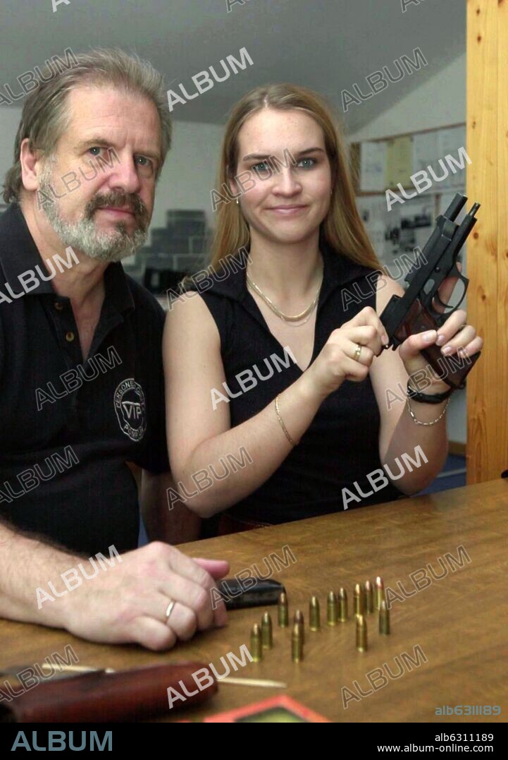 Horst Pomplun und Undine Kania. (dpa) - Horst Pumplun, owner of the bodyguard school 'VTP Personenschutz Pomplun', pictured with his 21 year old student Undine Kania who poses with a gun in a classroom of the school in Potdam, Germany, 15 May 2002. The vocational training for bodyguards comprises six levels with about 140 lessons each. 15/05/2002
