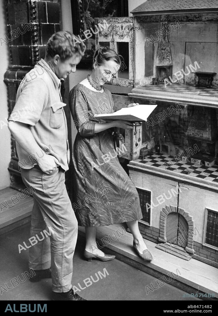 Stockholm 1960-08-03. koreografen Birgit Cullberg och dekoratören Per Falk tittar på köksinteriörer från 1800-talet i ett dockskåp på Nordiska museet. Foto: SvD / TT / kod 12014.