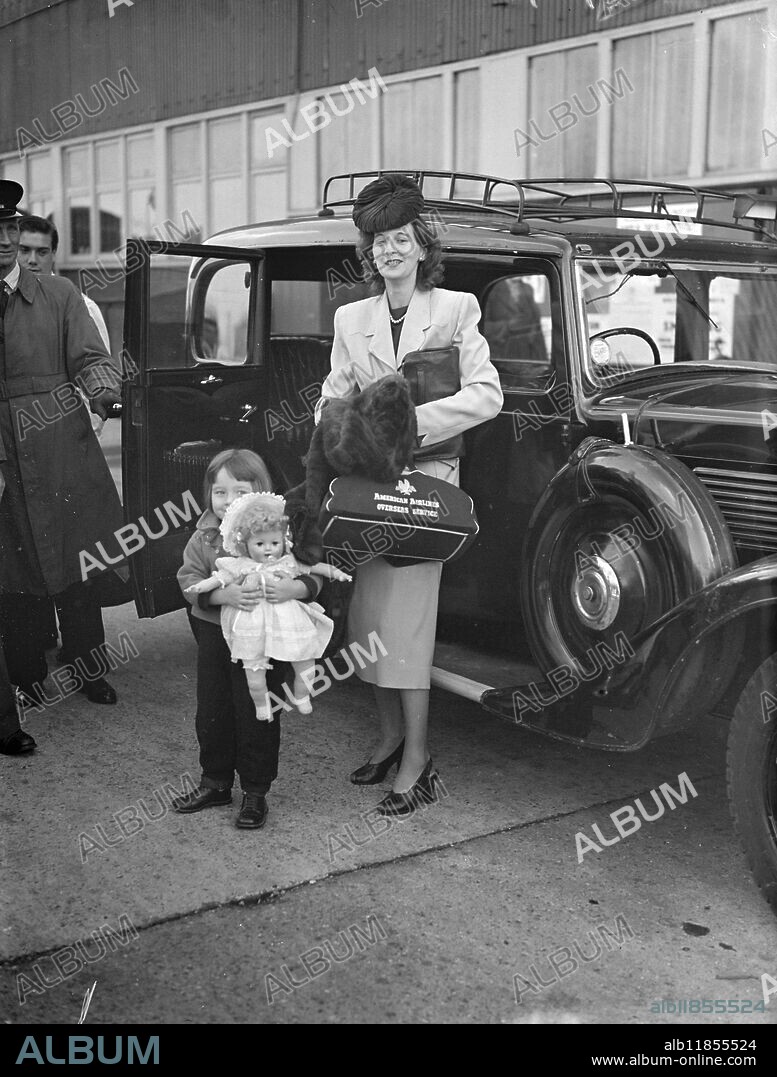 LINER-TAXI-LINER-DASH- HOLIDAYMAKERS DELAYED BY GALE . Mrs.Sheila Sheridan, London-born wife of an American merchant Navy man, and her daughter, Anne, aged three, (who refuse to let go of her doll despite the rush) pictures as they entered a taxi freight dock-side â" from the liner ' Queen Elizabeth' to the ' Athlone Castle' at Southampton. because the' Queen Elizabeth ' had been delayed twenty-five hours by the phenomenal Atlantic gales, Mrs.Sheridan and her daughter had only fifteen minutes to catch the ' Athlone Castle ' en route to Cape Town for a holiday. They had to hire a taxi to get there in time-but they made it . The Sheridans travelled from Boston, Massachusetts, U.S.A. October 27 1949.
