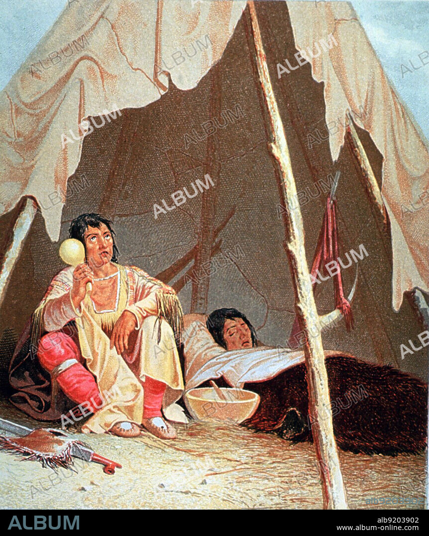 A native American Indian medicine man, holding a gourd rattle, is sitting in a tepee with a patient; there is a large bowl on the ground between them. Medicine man is an English terms used to describe traditional healers and spiritual leaders among Native American and other indigenous or aboriginal peoples.