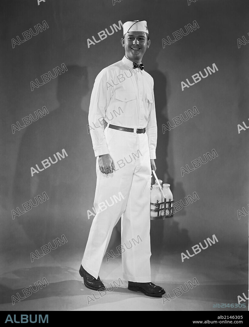 Milkman in uniform carrying a crate of milk.