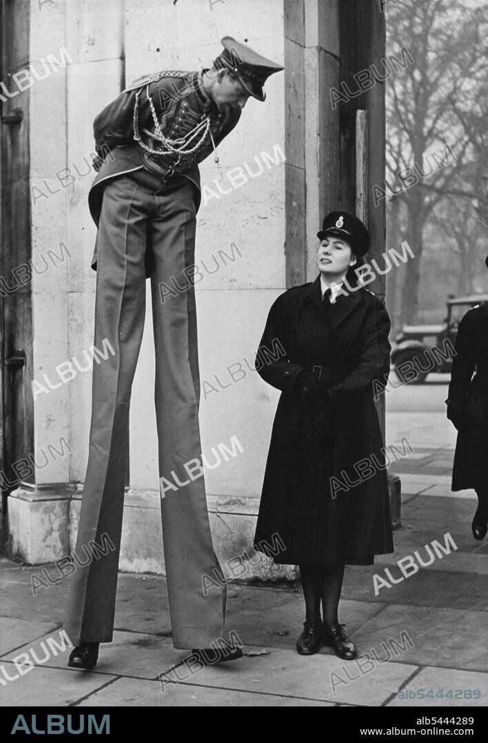 Policewoman Deals With a Tall Boy Henry Lewandowski, stilt-walker in Bertram Mills Circus receives a word of warning from a policewoman about littering Hyde Park with leaflets as the circus parade passed through today. ***** today saw the circus parade, as elephants ***** other attractions of Bertram Mills Circus passed through the streets on their way to Olympia from Victoria Station. December 17, 1951. (Photo by Fox Photos).