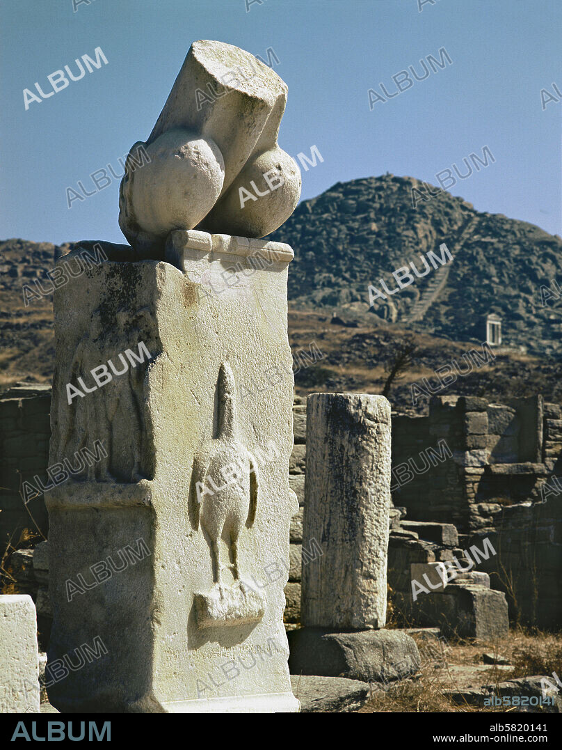 Dionysos sanctuary, Delos, monumental phallus with a relief of the phallus-bird, a symbol of the God, carried in procession or drawn on a chariot during Dionysian rites. Inscription says monuments were donated by Karystos, son of Asbelos. Around 300 BCE.