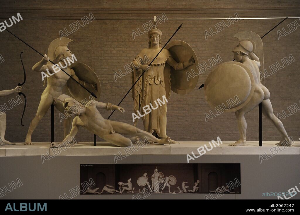 ARTE GRIEGO. GRECIA. Reconstrucción del grupo escultórico del frontón Oeste del Templo de Aegina. El original fechado hacia el 500 a. C. Guerreros troyanos y griegos junto a la diosa Atenea. Glyptothek. Munich. Alemania. Europa.