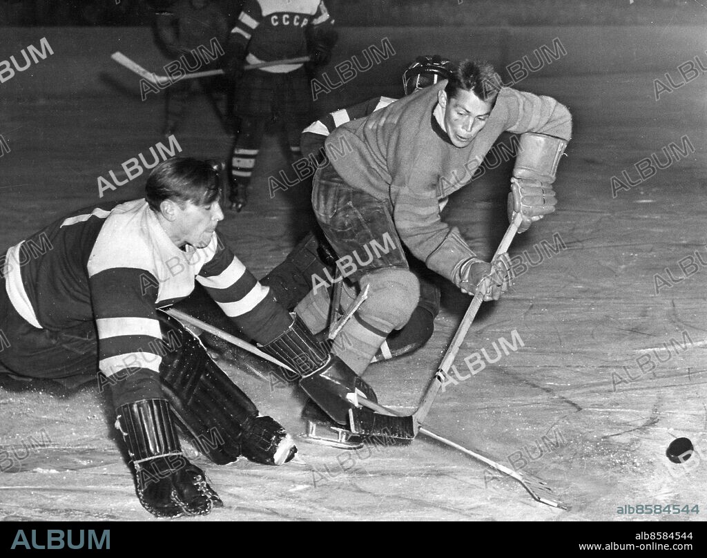 1955-12-09.. Sverige möter Ryssland i en ishockeylandskamp. Här ses Sigge Bröms vara nära den hägrande ryska målkassen men målvakten Nikolaj Putjkovs klubba är alltför snabb och slår undan pucken.. Foto: Owe G. Sjöblom / AB Text & Bilder / SVT / Kod: 5600. Mapp: Ishockey (svensk): Landskamper mot Sovjet I:35. Matchbilder Landskamper . Nikolaj Putjkov.