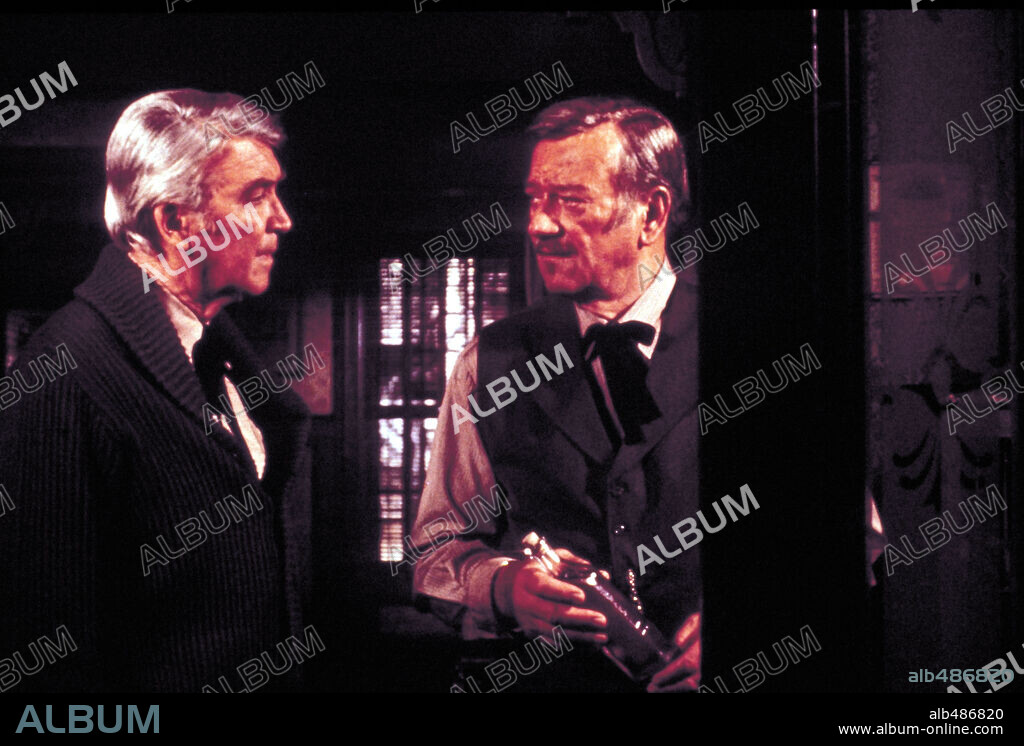 JAMES STEWART and JOHN WAYNE in THE SHOOTIST, 1976, directed by DON SIEGEL. Copyright PARAMOUNT PICTURES.