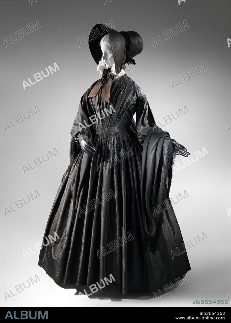 Mourning dress. Culture: American. Date: ca. 1845.
During the first half of the nineteenth century, the growing circulation of fashion magazines offering guidance on appropriate mourning styles increased demand for mourning attire, which became an indicator of middle-class status. Those unable to afford the purchase of a new mourning wardrobe could dye existing garments and accessories black, while others turned to a range of retailers. Shops specializing in mourning goods had existed since the eighteenth century, though by the mid-nineteenth century they operated on a greatly enhanced scale, aided by the mechanization of the textile industry, which permitted the mass-production of fabrics. From the 1840s, mourning warehouses--grand purveyors of mourning goods--were founded in many European and American cities, making such merchandise widely available. These establishments offered a variety of mourning fabrics and accessories, and many also offered the sewing of finished garments, emphasizing their ability to work at great speed.