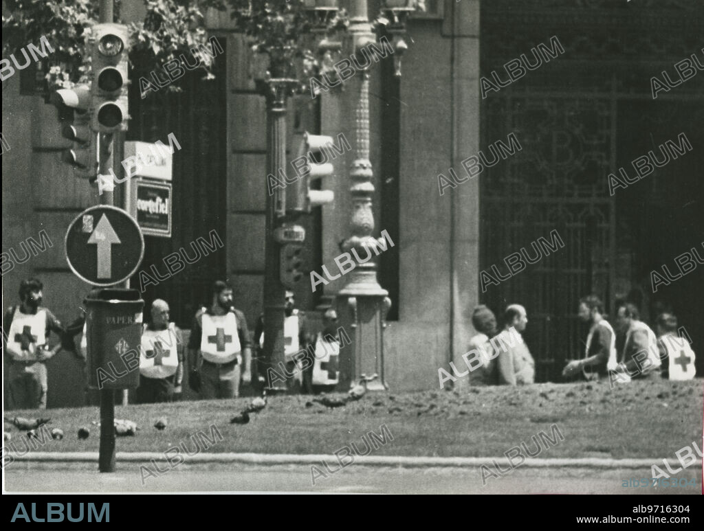 Barcelona 05/23/1981. Robbery at the Central Bank of Barcelona. The robbers entered the headquarters, a seven-story building in Plaza de Cataluña, on May 23. The GEO acted on Sunday the 24th, arresting nine of the eleven assailants. One more was killed. In the image, members of the Red Cross after providing food for the hostages, talking with one of the robbers who, masked, is hiding behind a hostage.