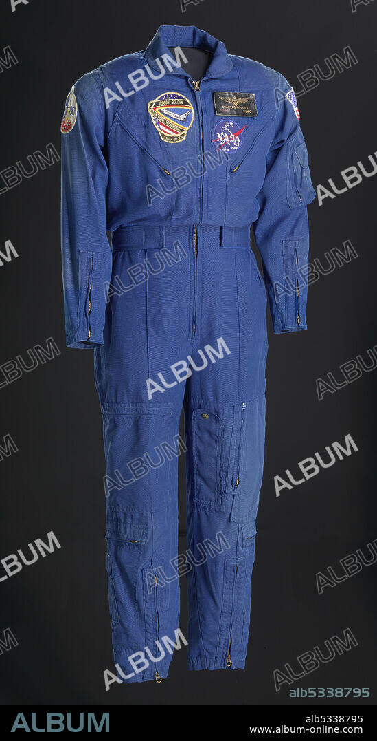 GIBSON & BARNES. African-American astronaut Charles Frank Bolden Jr. (born 1946) flew on four Space Shuttle missions. He was also a NASA administrator and a United States Marine Corps Major General. Blue full body flight suit worn by Bolden with zippers in the front and has several pockets and patches on it. The front of the suit has three patches on the chest. On the PR breast is the mission patch for STS 61C and features a circular design with an image of the space shuttle and a band displaying the names of the mission's astronauts. On the PR breast is a circular NASA logo patch, above which is a leather nametag reading [CHARLES BOLDEN / MAJOR USMC]. The nametag is a dark leather with golden text and pilot's insignia. On the PR shoulder is a circular patch for the 1980 NASA Astronaut Groups 9, which features the year and a space shuttle launching with nineteen white stars. The PL shoulder has an American flag patch. There are Velcro straps at the waist and zippered sections on the arms and legs for adjustments. The legs have a number of zippered pockets. A manufacturer's tag with handwritten details is sewn to the inside of the suit.
