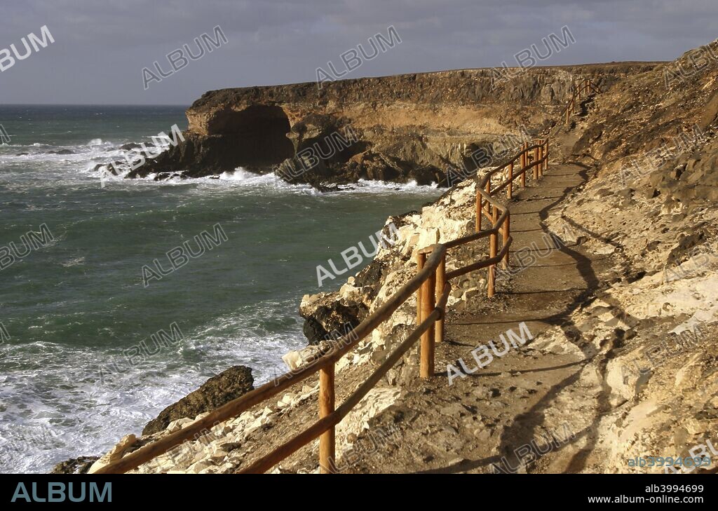 Coastal path, Puerto de la Pena, Ajuy, Fuerteventura, Canary Islands. Puerto de la Pe±a is a small settlement near Ajuy that used to be the port of the old island capital of Betancuria. The port was later raided by pirates.