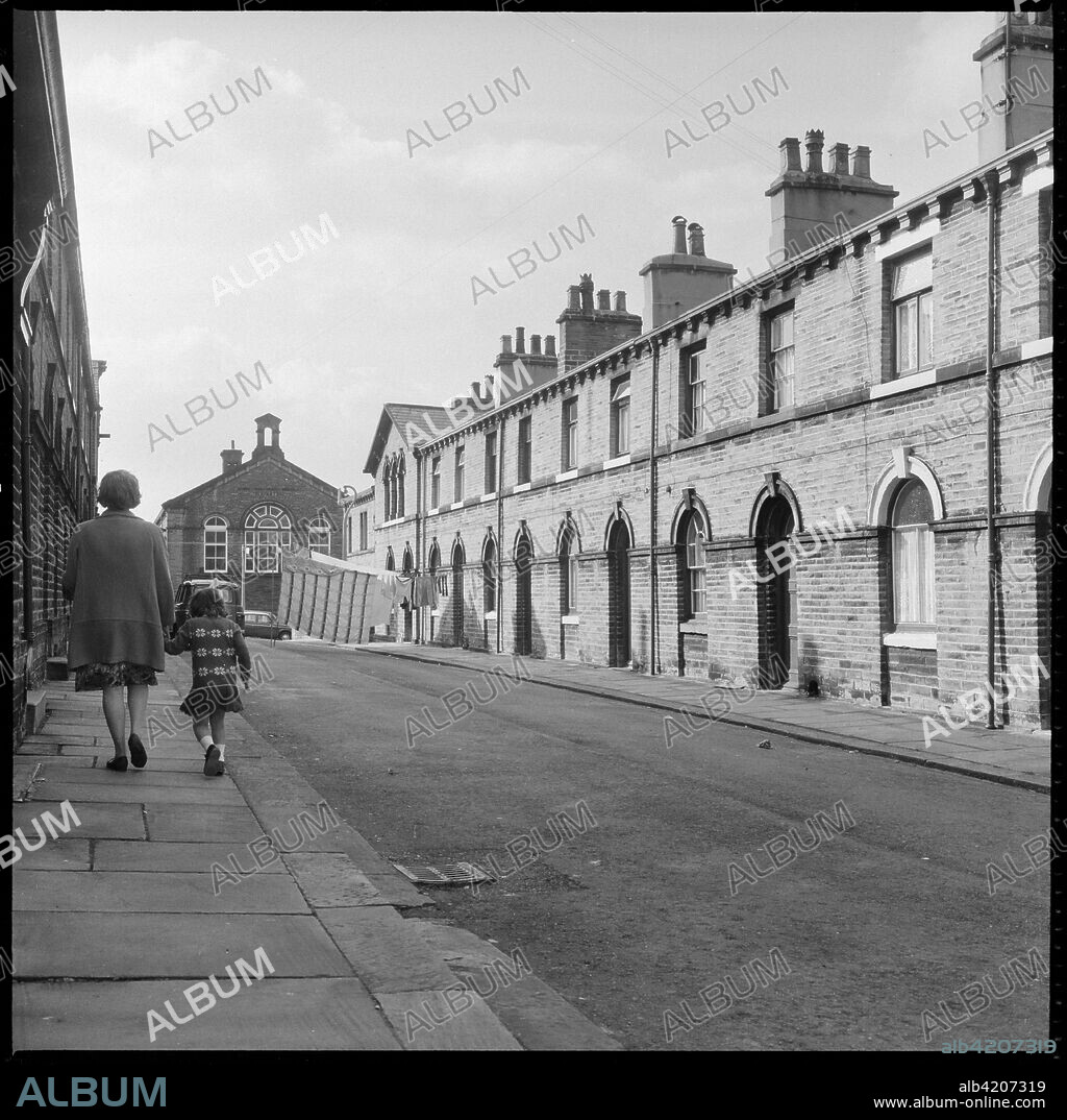 Shirley Street, Saltaire, Shipley, Bradford, West Yorkshire, 1966-1974. A view looking west along Shirley Street with Saltaire Primary School on Albert Road visible in the background.