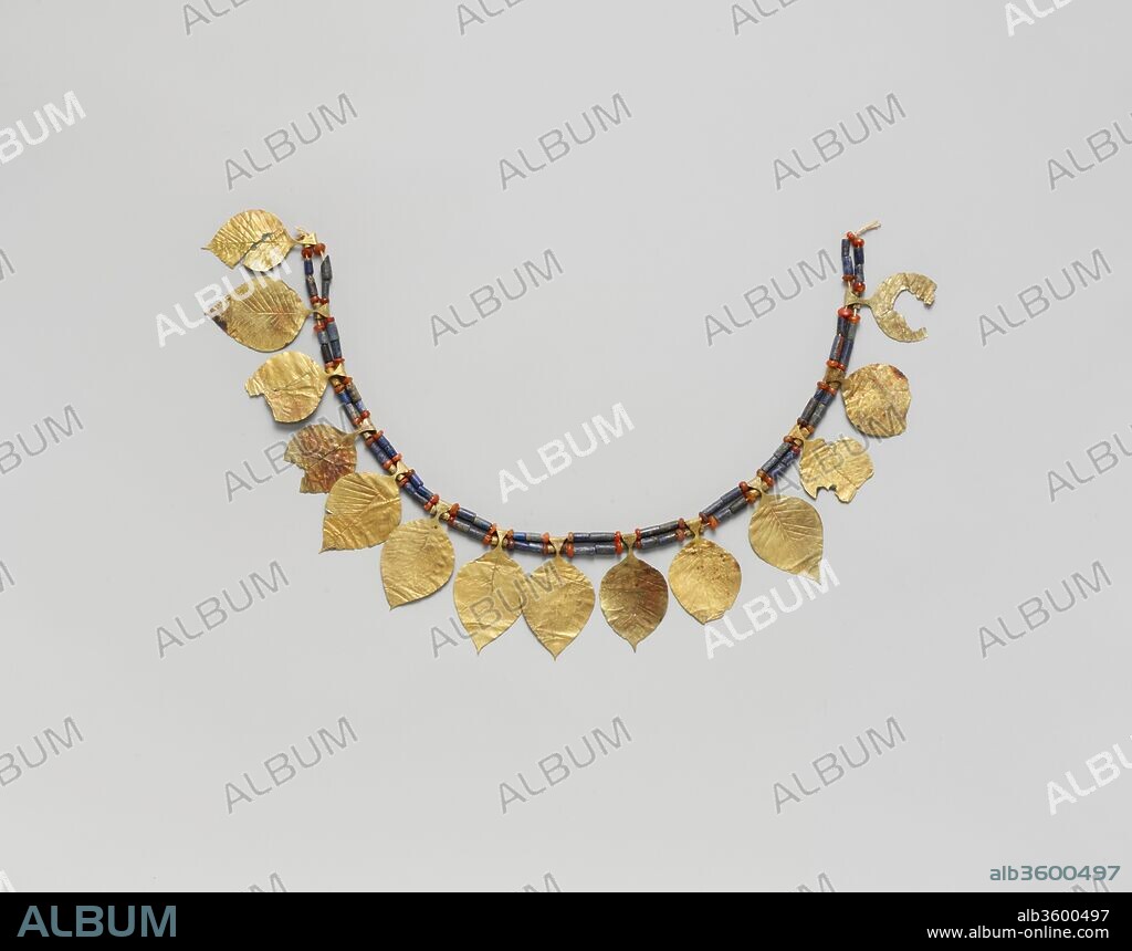 Headdress. Culture: Sumerian. Dimensions: L. 15 1/8 in. (38.5 cm). Date: ca. 2600-2500 B.C..
Kings and nobles became increasingly powerful and independent of temple authority during the course of the Early Dynastic period (2900-2350 B.C.), although the success of a king's reign was considered to depend on support from the gods. A striking measure of royal wealth was the cemetery in the city of Ur, in which sixteen royal tombs were excavated in the 1920s and 1930s by Sir Leonard Woolley. These tombs consisted of a vaulted burial chamber for the king or queen, an adjoining pit in which as many as seventy-four attendants were buried, and a ramp leading into the grave from the ground.
This delicate chaplet of gold leaves separated by lapis lazuli and carnelian beads adorned the forehead of one of the female attendants in the so-called King's Grave. In addition, the entombed attendants wore necklaces of gold and lapis lazuli, gold hair ribbons, and silver hair rings. Since gold, silver, lapis, and carnelian are not found in Mesopotamia, the presence of these rich adornments in the royal tomb attests to the wealth of the Early Dynastic kings as well as to the existence of a complex system of trade that extended far beyond the Mesopotamian River valley.