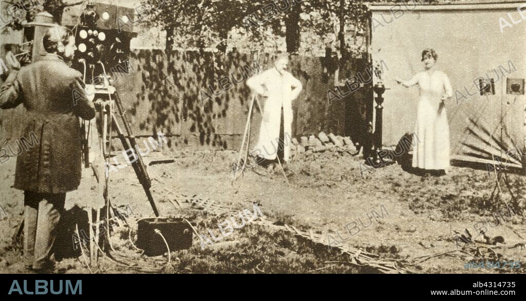 Eugene Lauste recording the first combined moving image and sound, c1905, (1935). 'Eugene Lauste may be seen already experimenting with "Talkies". In his back garden at Brixton he is taking the first combined movie and sound picture'.  French inventor and cinematographer Lauste (1857-1935), centre, filming with his sound on film camera in his garden in Brixton, south London. From "The Silver Jubilee Book - The Story of 25 Eventful Years in Pictures". [Odhams Press Ltd., London, 1935].