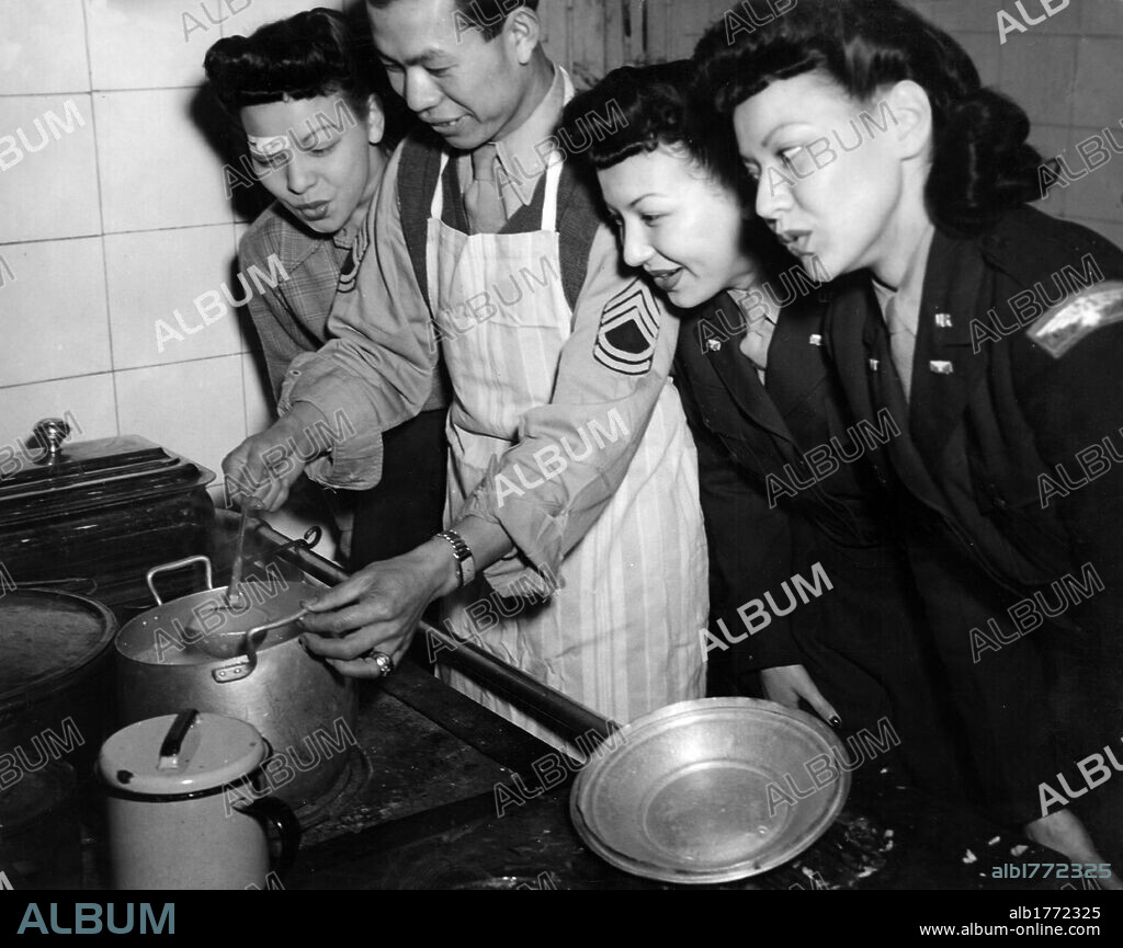 The Kim Loo sisters. The Kim Loo sisters in auxiliary uniform watching an Oriental soldier cooking a typical Chinese meal during a stop for a show at a base of the U.S. 15th Air Force. Italy, October 1944.