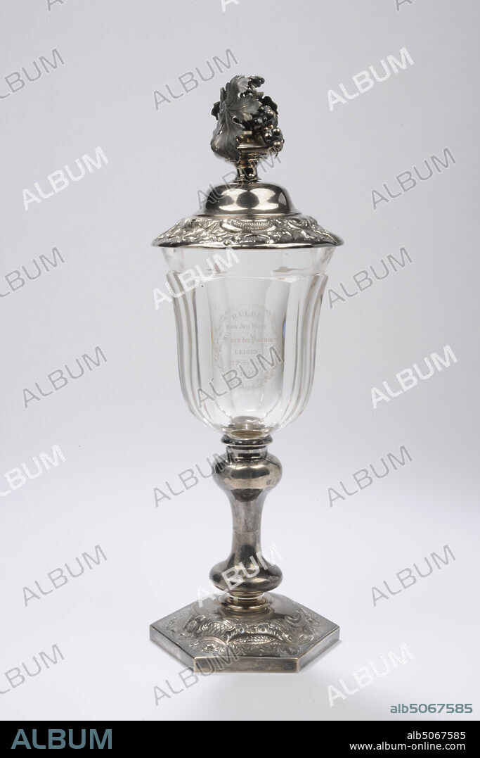 goblet, Zilverfabriek J.M. van Kempen en Zn, Voorschoten, 1858, silver, glass, Bowl and lid: 33.5 x 11.4cm 335 x 114mm, Bowl: 24.3 x 11.6cm 243 x 116mm, Lid: 9.5 x 11.4cm 95 x 114mm, diam. chalice: 10.4 cm / diam. base: 11.3 cm, crystal bowl with silver lid and silver base. The goblet has a hexagonal arched foot, which is decorated on top with engraving and gearing, depicting flower, leaf and ornamental motifs. The silver trunk is made up of a disc-shaped base nodule, a smooth stem and an inverted baluster-shaped knot. The chalice-shaped cup is made of thick glass and cut in six facets. Above that a slightly flared smooth edge. On one of the faces of the chalice is an oval wreath of leaf and bud motifs gathered in a ribbon at the bottom. Here is a text engraved in six lines under each other: HULDE to Mr. [slant] S. van der Paauw [slant] Leiden February 12, 1859. Parts of the text are decorated with curls. The silver lid with a floating rim is crowned by a bunch of grapes and two vine leaves. The edge of approximately three centimeters wide is driven with ornamental C-scrolls and rose and leaf motifs. Small air bubbles in chalice, 1922.