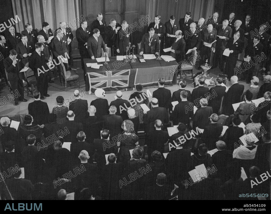 The Duke Becomes Grand Master Of Air Pilots The Duke of Edinburgh, seen at centre of table, is installed as Grand Master. Investing him with badge of office is the Guild's Hon. Chaplain, the Rev, Leslie Wright, Cre, MA. The Duke of Edinburgh was installed as Grand Master of the Guild of Air Pilots and Air Navigators of the British Empire in an impressive ceremony at the Grocers' Hall, London, E.C. to-night (Thursday). The Guild was founded in 1929 on the lines of the old city Guilds. Its main objects are to further the efficiency of mercantile flight and upheld the dignity and prestige of air pilots and air navigators. The Queen is the Patron. October 22, 1953. (Photo by Reuterphoto).