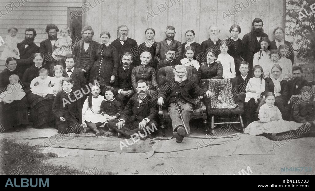 Familia Lloyd-Jones, 1883. A group portrait of about 40 members of the Lloyd Jones family. The empty chair in the front row was placed in memory of the wife of Richard Lloyd Jones.
In the back row, from the left are Enos holding Chester, James holding Scott, John, Nettie, Thomas B. Jones, Margaret, Thomas, Esther, William Carey Wright and his wife Anna (Frank Lloyd Wright's parents), James Philip, and Mary. In the middle two from the left are Elinor holding Agnes, Laura holding Maud, J. Richard holding Gwen, Orren, Ellen, Edward, M. Helen, Jane (with her niece Jane standing behind her), Elsie, Margaret, and Anna Nell. In the front row from the left are Thomas, Mary, Jenkin, Charles, Richard, Frank Lloyd Wright holding his sister Maginel, Susan with Mary Lloyd at her feet, and Jenkin with Richard at his feet.