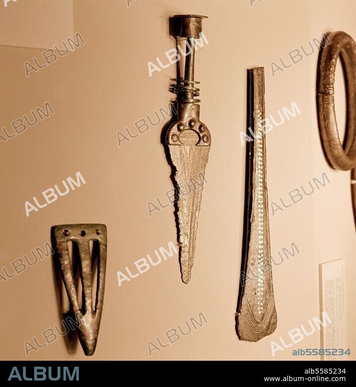 Frühe Bronzezeit, Schweiz, A 2, um 1600 v. Chr. Gürtelhaken, Dolch und Beil. Teile einer Grabausstattung. Bronze, Breite des Beils 24,1 cm. Fundort: Thun "Renzenbühl", Kanton Bern, Schweiz. Inv. Nr. BHM 10327ff. Bern, Bernisches Historisches Museum.