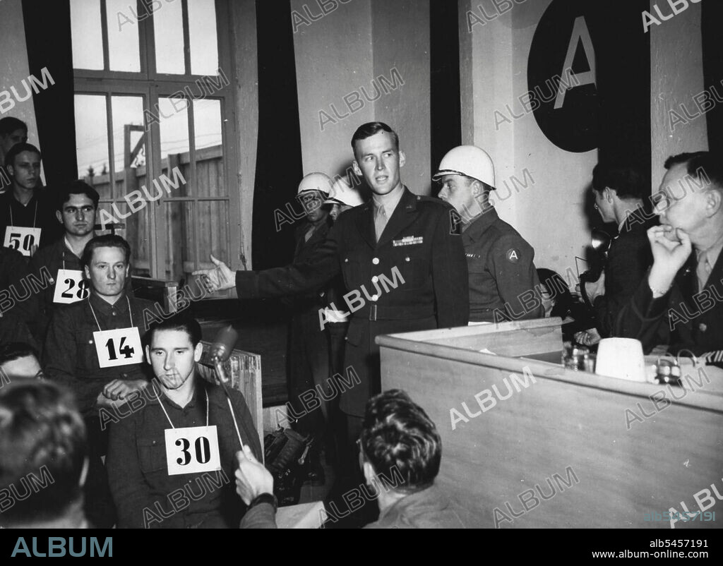 Accuses German of starting Malmedy Massacre -- Virgil P. Lary of Lexington, Ky., former first Lieutenant in the United States field. Artillery, points to George Fleps, 32 year-old former S.S. Trooper, and identifies him as he massacre of American prisoners near Malmedy, Belgium, December 17, 1944. This scene in the current war crimes trial at Dachu, Germany, took place, May 21, 1946. June 11, 1946. (Photo by Associated Press Photo).