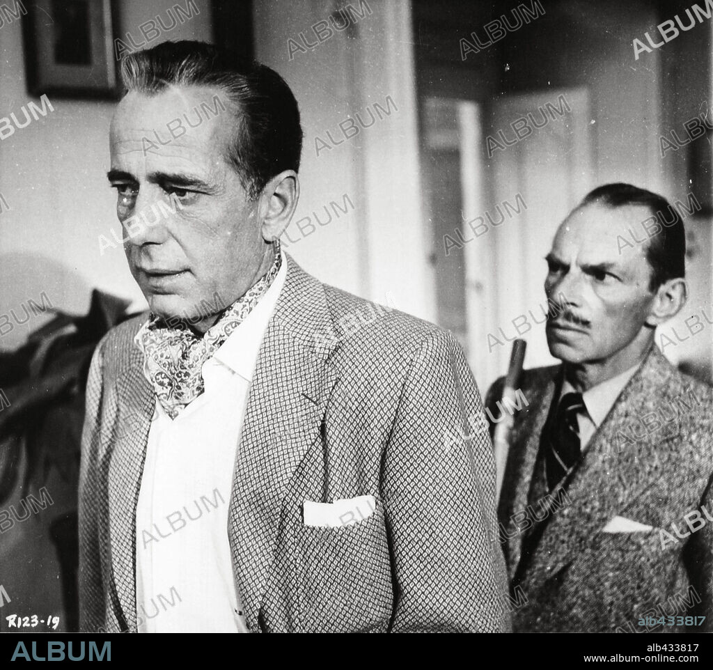 HUMPHREY BOGART and IVOR BARNARD in BEAT THE DEVIL, 1953, directed by JOHN HUSTON. Copyright UNITED ARTISTS.