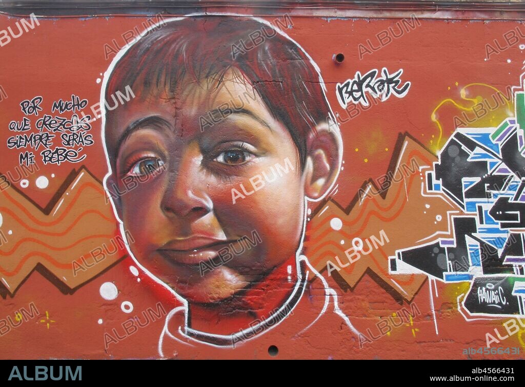 Pintura de niño sonriente y dulce mirada, graffiti mural, calle Selva de Mar, barrio Poblenou, Barcelona en 2016.