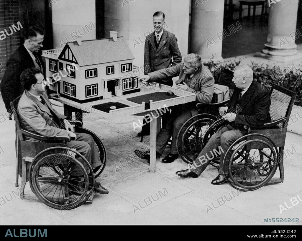 Modern Dolls house Made for Princess by Disabled Soldier - Mr. Ben Johnson (second from right) opening one of the tiny windows of his dolls' house for the inspection of other disabled soldiers at their Richmond home.A wonderful dolls' house, furnished and decorated in modern style, has been built by Mr. Ben Johnson, an ex-service man at the star and garter home for disabled soldiers here, and is to be presented to Princess Margaret Rose, younger daughter of the Duke and Duchess of York. It has taken nine months to make and is equipped with a sun-terrace, a labour saving kitchen, nurseries, and tiny furniture all built to scale. October 12, 1936. (Photo by Associated Press Photo).