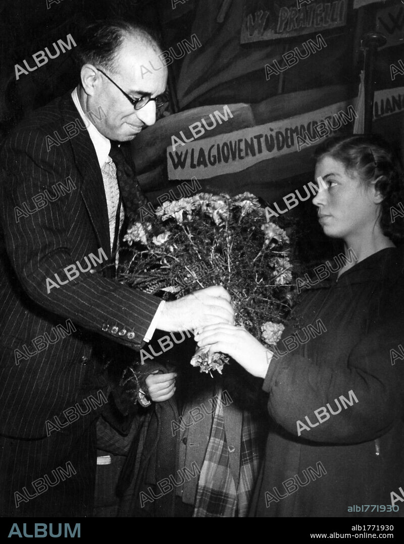 Mario Scoccimarro and Velia Perini. The vice-chairman of the Communist Youth Movement Mario Scoccimarro receiving a bouquet of flowers from Velia Perini. Rome, November 1944.