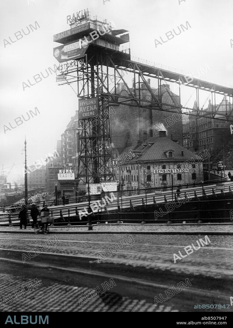 STOCKHOLM 1930-tal.. Orig. bildtext... SLUSSEN KATARINAHISSEN Anm. Järnkonstruktioner Skyltar Bensinstation Numa Radio Stomatol sites: STOCKHOLM;SVERIGE.