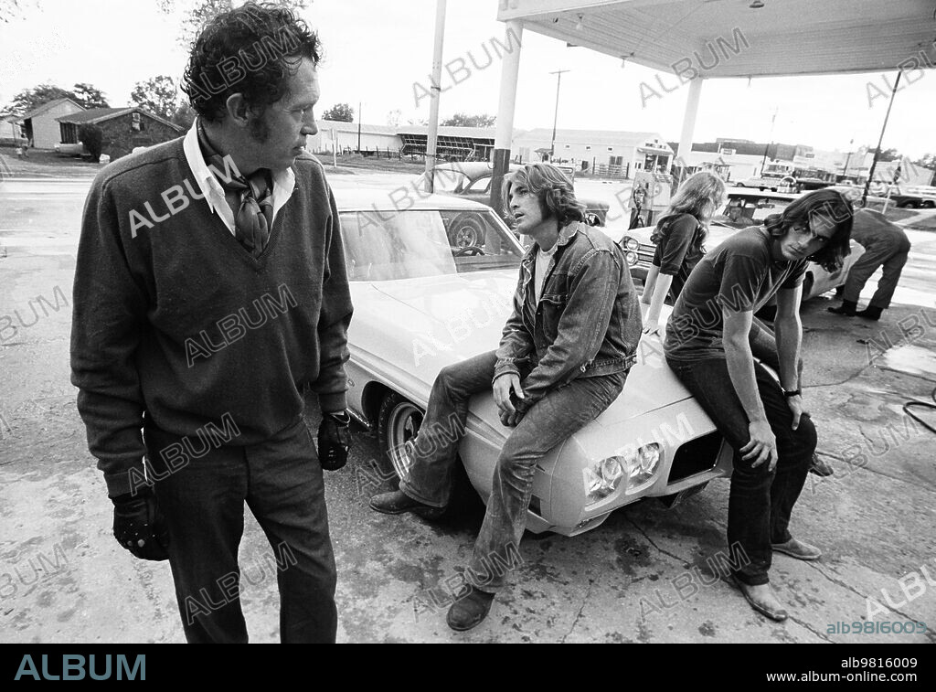 DENNIS WILSON, JAMES TAYLOR and WARREN OATES in TWO-LANE BLACKTOP, 1971, directed by MONTE HELLMAN. Copyright UNIVERSAL PICTURES.