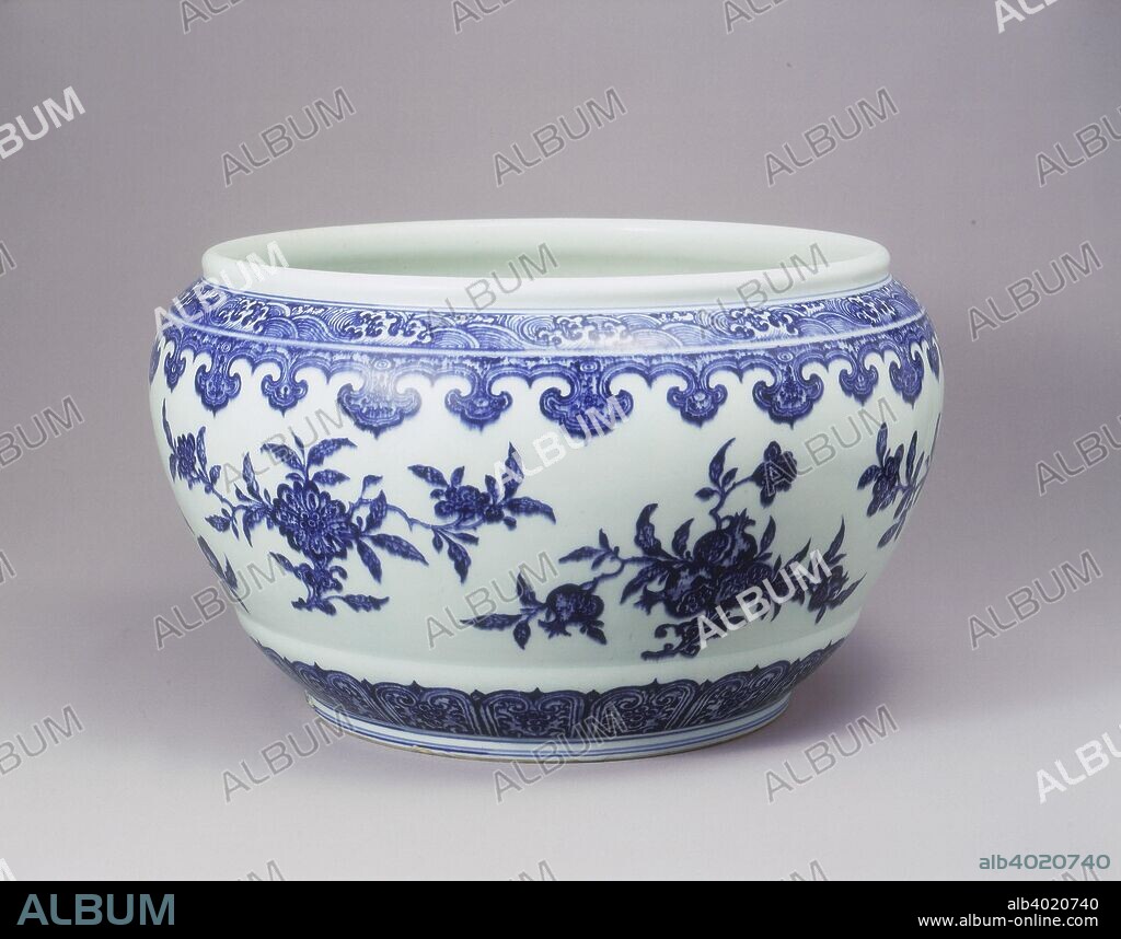 Blue and white fish bowl in Ming style, Yongzheng period, Qing dynasty, China, 1723-1735. A large blue and white fish bowl in Ming style with a wide mouth, the rounded sides tapering to a raised band around the base. It is painted with stylised petal lappets radiating from the shallow ring-foot, below a broad frieze of six meticulously drawn fruiting and flowering branches including peaches, pomegranates, lotus and peony, each rising from a lingzhi sprig. The narrow shoulders with trefoil lappets pendant from a collar of wave scrolls at the base of the plain moulded lip. The underglaze blue is of vivid tone with extensive heaping and piling to simulate the 15th century prototype.The base with underglaze blue 6 character seal mark.
