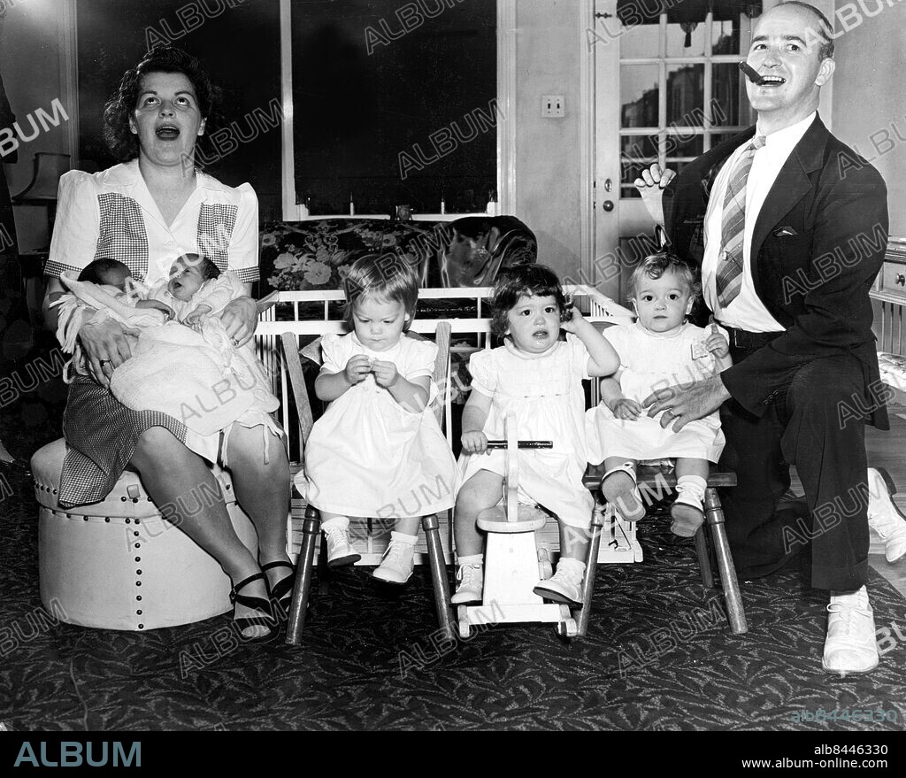 Orig. bildtext... TWINS TRAIL TRIPLETS BY 14 MONTHS Philadelphia, Pa. Mrs Betty Macatee holds her two-week-old twins, Dolores and Bernadette, as she registers a what next expression, while proud papa Raymond Macatee puffs on a big black cigar and holds his lapel in the traditional manner. The triplets born 14 months ago are (l. to r.) Bett Ann, Rose Mary and Ilene Marie. The father is a street car conductor. Anm. Syskon Trillingar Tvillingar Cigarrer Bildarkivets katalog nr4.10 sites: USA.