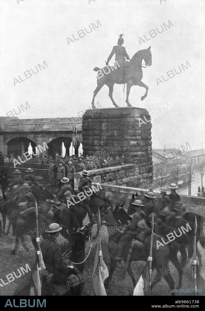'Les Anglais sur le Rhin; "La meprisable petite armee" anglaise franchit le Rhin le 12 decembre 1918: non sans humour, ou peut-etre par hasard, le general Plumer commandant la 2e armee britannique, s'etait place avec son etat-major au-dessous du piedestal supportant la statue equestre de Guillaume II, a l'entre du pont Hohenzollern, a Cologne, pour voir sa cavalerie passer sur la rive droite', 1918. From "L'Album de la Guerre 1914-1919, Volume 2" [L'Illustration, Paris, 1924].