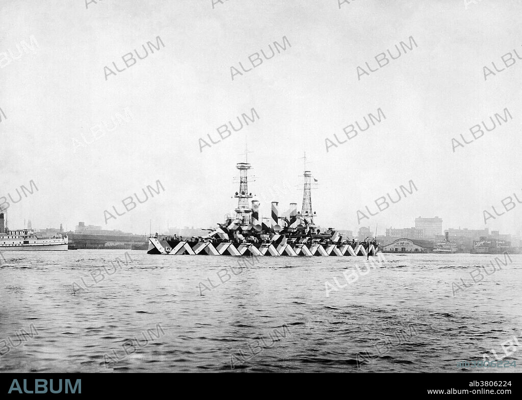 USS Nebraska with dazzle camouflage, US Navy Yard, Norfolk, Virginia. April 20th, 1918. Dazzle camouflage, also known as razzle dazzle or dazzle painting, was a family of ship camouflage used extensively in World War I and to a lesser extent in World War II and afterwards. Credited to artist Norman Wilkinson, though with a prior claim by the zoologist John Graham Kerr, it consisted of complex patterns of geometric shapes in contrasting colors, interrupting and intersecting each other. Unlike some other forms of camouflage, dazzle works not by offering concealment but by making it difficult to estimate a target's range, speed and heading.