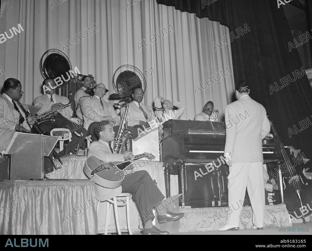 WILLIAM PAUL GOTTLIEB. Portrait of Duke Ellington, Junior Raglin, Juan Tizol, Barney Bigard, Ben Webster, Harry Carney, Rex William Stewart, and Sonny Greer, Howard Theater(?), Washington, D.C., 1938.