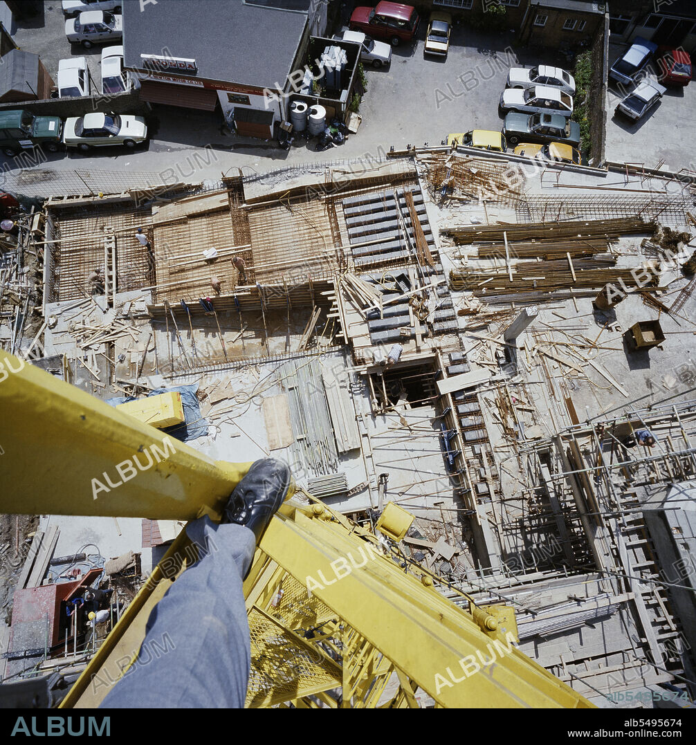 JOHN LAING PLC. South Norwood Police Station, Oliver Grove, South Norwood, Croydon, London, 04/06/1987. An elevated view of the construction site for South Norwood Police Station, from the perspective of a man who is standing on a tower crane. Laing’s Southern Region was awarded a £3.8m contract by the Metropolitan Police for the construction of a divisional police station at South Norwood. Work began at the 2100 square metre site in 1986. The structure comprised a reinforced concrete framed building and reinforced concrete basement with brick cladding, services and external works.