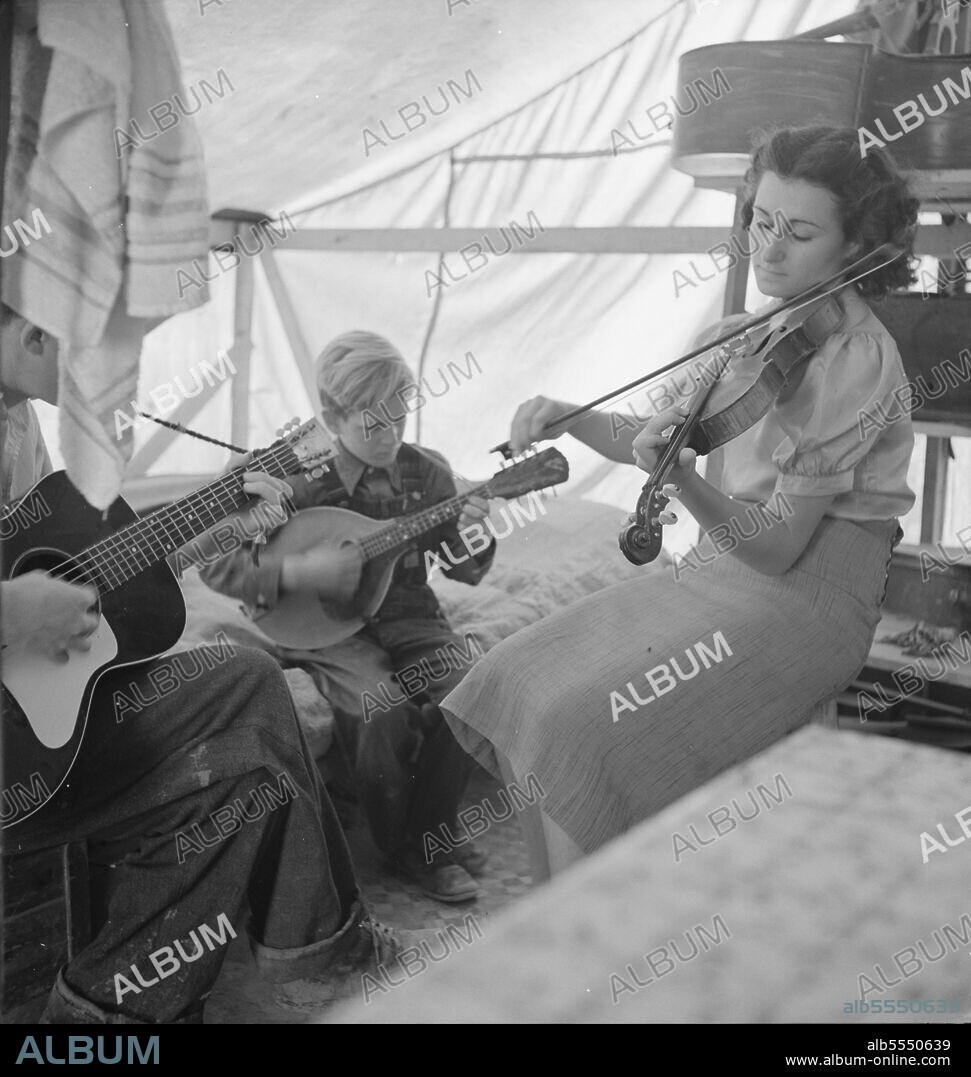 DOROTHEA LANGE. Migrant family from Arkansas playing hill-billy songs. Farm Security Administration emergency migratory camp. Calipatria, California.