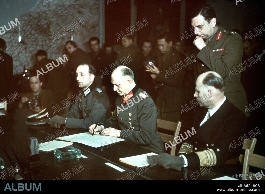 HANS GEORG VON FRIEDEBURG, ALFRED JODL and WILHELM OXENIUS. Colonel General Alfred Jodl (m) is signing the capitulation; his adjutant Colonel Wilhelm Oxenius on the left; Admiral Georg von Friedeburg on the right. 07/05/1945