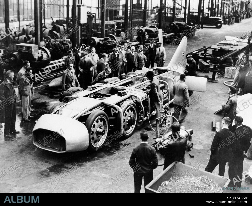 Captain George Eyston's 'Thunderbolt' car, 1937. Eyston set three Land Speed Records in this car at Bonneville Salt Flats, Utah, USA, the fastest being 357.49 mph on 16th September, 1938.The record changed hands several times between Eyston and fellow Briton John Cobb in the late 1930s. Here the car is seen partially assembled, surrounded by mechanics and onlookers.