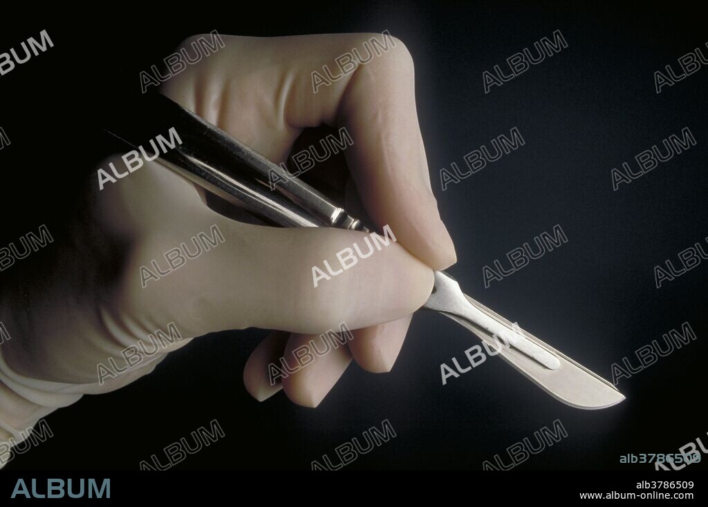 Hand holding scalpel.