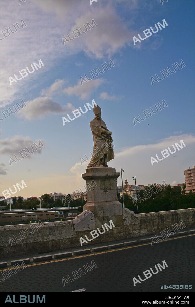 València, Comunidad Valenciana, Spain, Europe. Baroque stone statue of Saint Thomas of Villanova (San Tomas de Vullanueva) at the Trinity Bridge (Puente de la Trinidad). The bridge was built in the Gothic style by Pedro Viñes in the 14th century, on the remnants of a Moorish bridge made of wood.