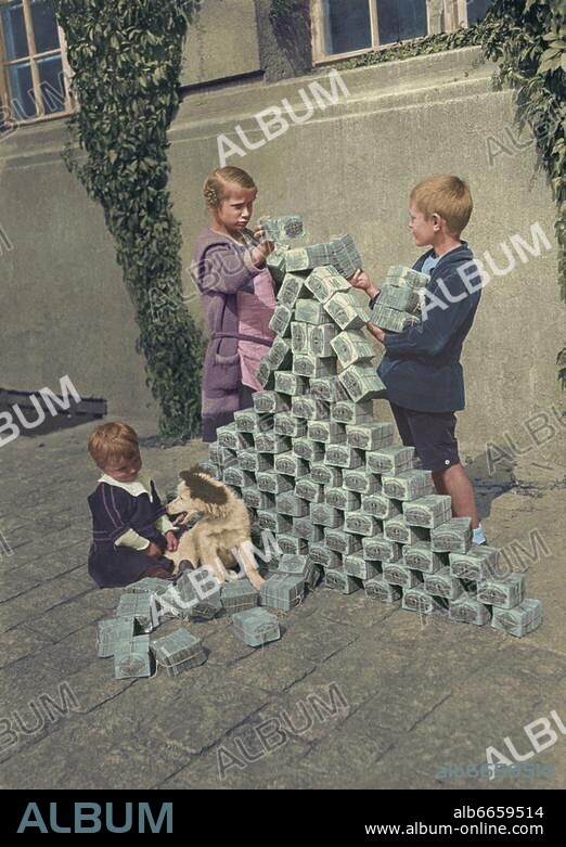 Monetary System / Banknote. Germany. Hyperinflation during the Weimar Republic. Children building a tower with blocks made of banknotes. Photo, 1923, digitally coloured.