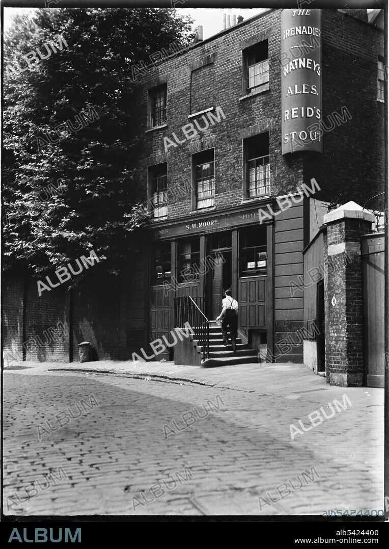 CHARLES WILLIAM PRICKETT. The Grenadier, Wilton Row, Belgravia, City of Westminster, Greater London Authority, 1935-1940. A view from the south-east showing the front of The Grenadier and a man walking up the steps to the entrance of the pub. In the Post Office directory of 1938, Sidney William Moore was recorded as being the landlord and in the photograph, his name can be seen above the door.
