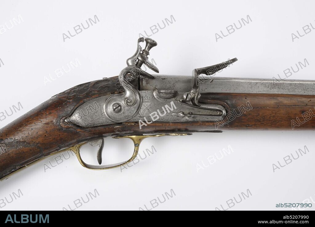rifle, Anonymous, 17th century, wood, iron, brass, engraved, Flintlock rifle with a so-called box barrel of a target rifle. The cock is engraved with a snake wrapped around the cock screw and there is a lofty volute as if it were a continuation of the edge of the lower cock lip. The lock plate has more or less parallel top and bottom edges and is engraved as follows. On the tail the coat of arms of Leiden, under a count's crown and with leaves under the shield. Before the cock an identical shield with leaves, but exaggerated with two crossed guns across a wavy horizontal line. At the front, partly over the battery spring, engraved in writing: Jan Bos / Leyde. The barrel is made of bare iron with a long rectangular, so-called box-shaped, breech. On the barrel, three convex bands precede a smooth panel on which are engraved vegetative curls that surround a swirl-shaped centerpiece. Further forward, two convex tires follow. Furthermore, the barrel is round in cross section and has longitudinal hammered panels. At the front, the barrel ends in a chalice-shaped trumpet, with a small grain in front and a flat trumpet surface. Between the chalice and the rest of the barrel is a long intermediate piece consisting of a central section engraved with vortex-shaped plants and two convex bands on the front and rear ends. A black mark is stamped in the left side of the breech. The butt and drawer are made of walnut. The drawer wood is embossed with plant and floral motifs around the barrel tail and the rear ramrod. The brass fitting consists of three ramrod sleeves, a trigger guard and a butt plate. The latter has a long undulating track on top. Also made of brass is the open worked and engraved screw plate, the decoration of which includes an engraved medallion with two crossed guns over a wavy line. , Dimensions Catalog dimensions: Total length: 163 cm; Barrel: 125.2 cm; Caliber: 1.05 cm, General: 163.