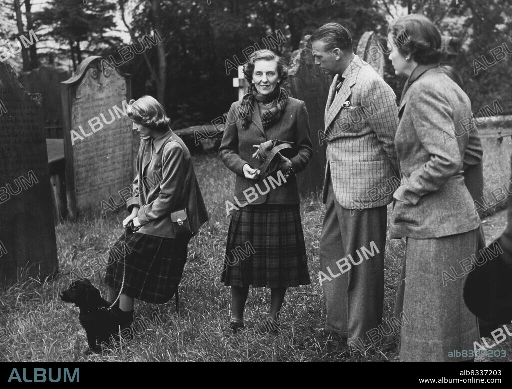 Photo Shows:- Pictured as they study the old gravestones in Durisdeer Church yard (1679) are the Duchess of Northumberland (left) elder, daughter of the Duke of Buccleuch; the Duchess of Buccleuch ; Mr Douglas Fairbanks the actor, and (hidden) Mrs Douglas Fairbanks. Gravestones dating from 1415 are decipherable. On right (foreground) is the Baroness Juel of Denmark. The Duke of Buccleuch's Party at Drumlanrig:- The Duke and Duchess of Buccleuch were hosts to Mr and Mrs Douglas Fairbanks, Baron and Barones Juel of Denmark, the Duchess of Northumberland and Mr Douglas Scott, among other at a shooting party at Drumlanrig Castle over the week end. Princess Margaret who was also a guest did not take part in the shoots. August 21, 1950. (Photo by Fox Photos).