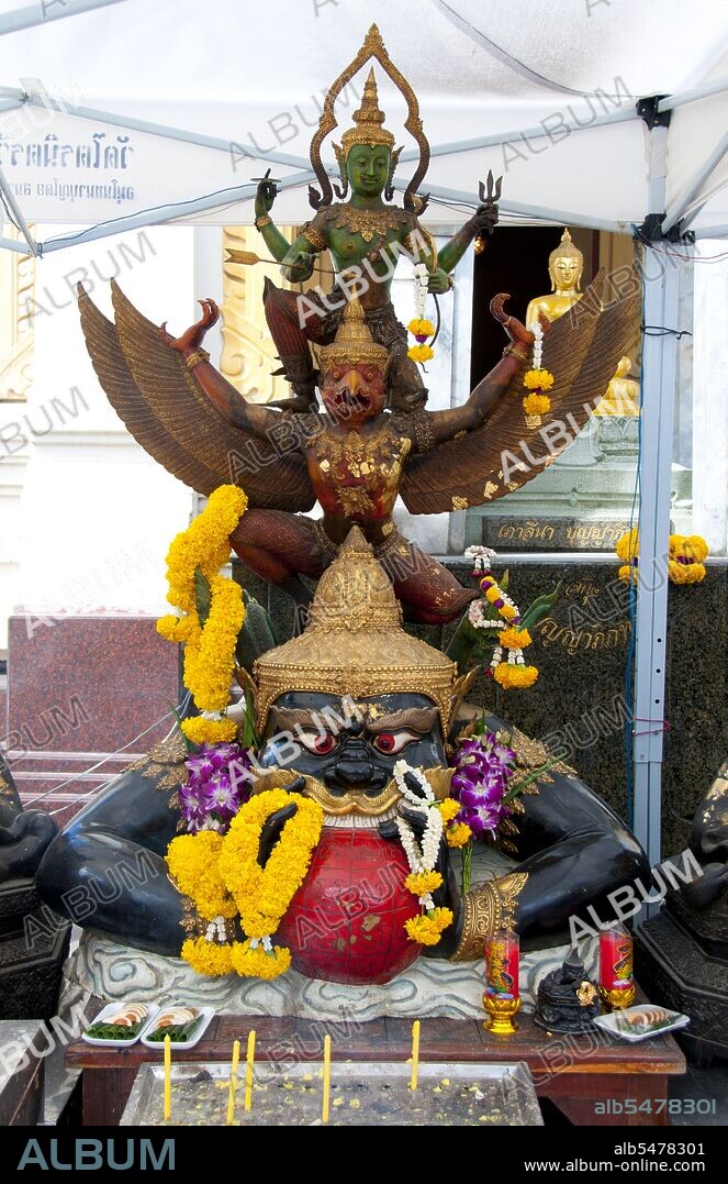 The National Emblem (National Symbol) of Thailand features the Garuda, a figure from both Buddhist and Hindu mythology. In Thailand, this figure is used as a symbol of the royal family and authority. This version of the figure is referred to as Krut Pha, meaning 'garu?a acting as the vehicle (of Vishnu). ' The National Emblem is also the Emblem of the King of Thailand. In Hindu mythology, Rahu is a snake that swallows the sun or the moon causing eclipses. He is depicted in art as a dragon with no body riding a chariot drawn by eight black horses. Rahu is one of the navagrahas (nine planets) in Vedic astrology. The Rahu kala (time of day under the influence of Rahu) is considered inauspicious. According to legend, during the Samudra manthan, the asura Rahu drank some of the divine nectar. But before the nectar could pass his throat, Mohini (the female avatar of Vishnu) cut off his head. The head, however, remained immortal. It is believed that this immortal head occasionally swallows the sun or the moon, causing eclipses. Then, the sun or moon passes through the opening at the neck, ending the eclipse. Wat Traimit is a Thai Buddhist temple found in the Chinatown area of Bangkok. It is chiefly known for housing the world's largest solid gold Buddha figure, the Phra Phuttha Maha Suwan Patimakon. The image is also the largest solid gold statue of any kind in the world.