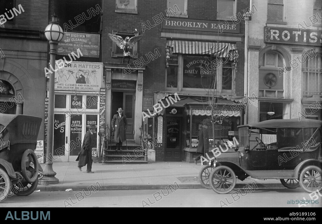 HARRIS & EWING. Brooklyn Daily Eagle, 1916. Newspaper office, New York City. Signs: 'Victoria Hat Cleaning - Hatters - Hats Cleaned and Reblocked - Equal to New'; 'Shoe Shine'; 'Suits Pressed'; 'Tait & Co. Suburban Real Estate'.