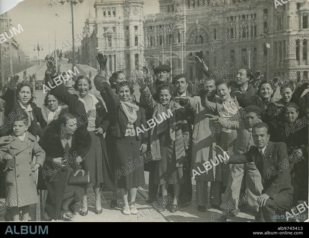 Madrid, 28/03/1939. Guerra Civil Española. Liberación de Madrid por las tropas nacionales, un grupo de hombres y mujeres alzando el brazo frente al Palacio de Comunicaciones.