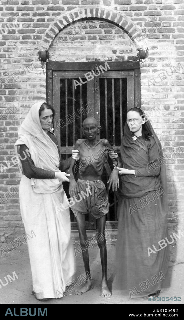 Photographic print of an emaciated famine victim standing in between Miss Neil and an unidentified woman. Dated 1910.